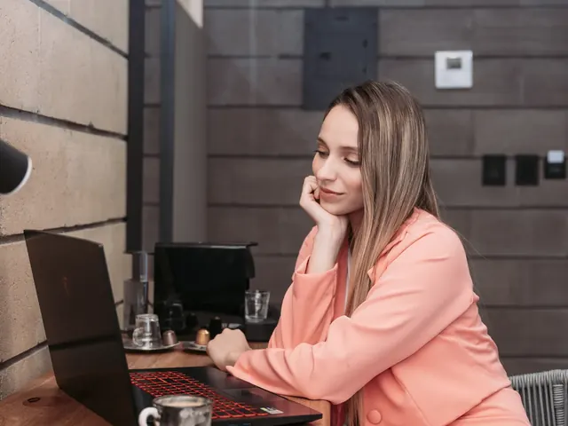 Guest working on a laptop with an espresso at a wooden desk, next to a capsule coffee machine, in a room at Living by Armóniko