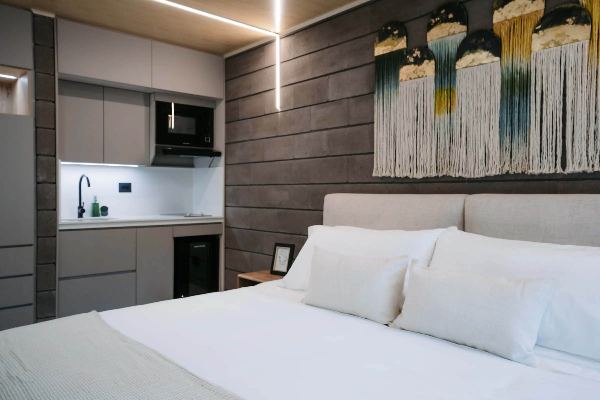 Suite de Living by Armóniko con cama doble y cocineta con lavaplatos, estufa, microondas y minibar